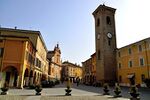 This is the square of Bagnacavallo. In this picture we can see the Clock Tower, the main church of Saint Michael and also some little porticoes. The "democratic" parts and the religious parts here are close to each other.