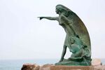 FISHERMAN WIFE - (44°04'54.6"N 12°34'36.2"E) In Rimini is possible to find this statue made of bronze, placed at the tip of the dock facing the open sea. The statue represent a woman with children on the shore waiting for her husband fishing in the sea. The scene is drammatic.The woman is aiming a point on the horizon trying to figure out where the husband fishing boat is, probably hoping to to see him coming back safely to the port. Till the XIX century this kind of risks were a big concern for families, in fact the sails of the fishing boats were all different from each other in order to make them recognizable from the shore. Each boat had its own particular sign on the sail, smartphones and GPS weren’t available back then. Fishing had always been part of Rimini's culture since it's on the coast, but in the last years it started losing its identity because of massive tourism from all over Europe. This sculpture wants to remember us our past, our origins, the respect for tough jobs such as fishing and most of all the respect for the sea as a force of nature and as a resource.FISHERMAN WIFE